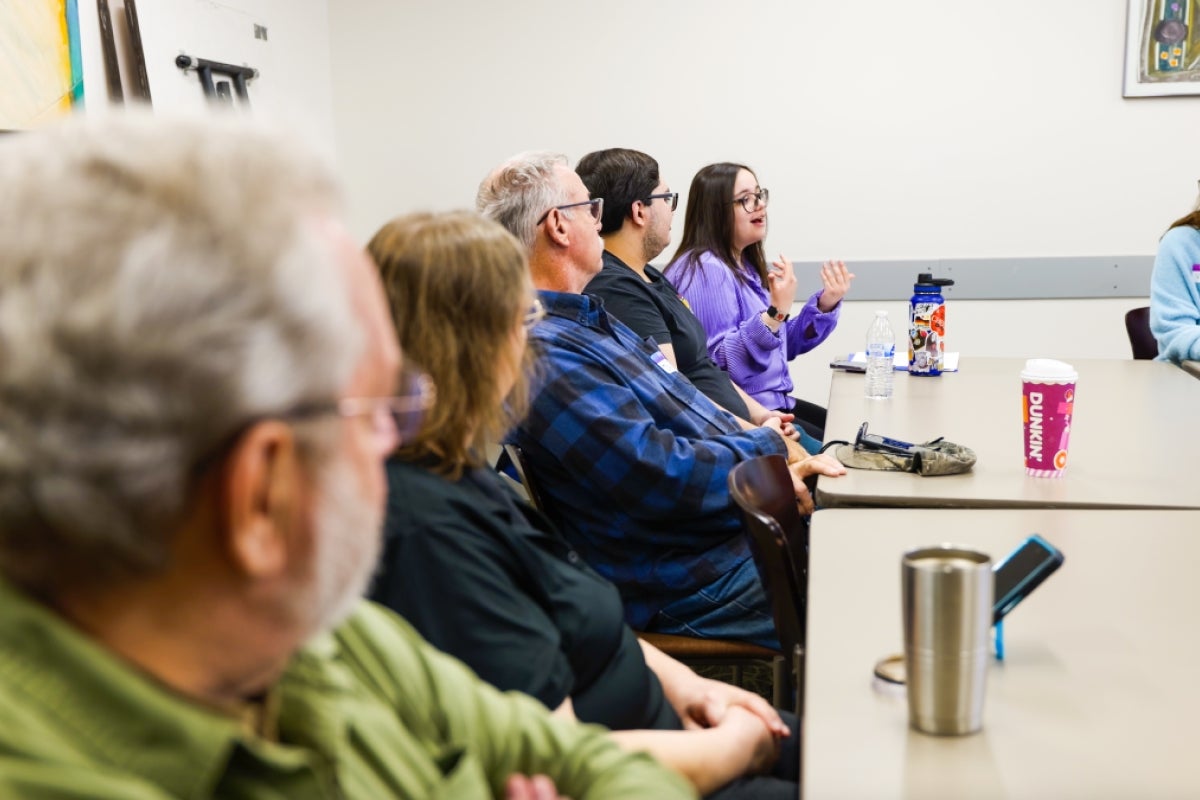 People sitting around a conference table discuss research findings. Photo by Ashley Sorensen/ASU.
