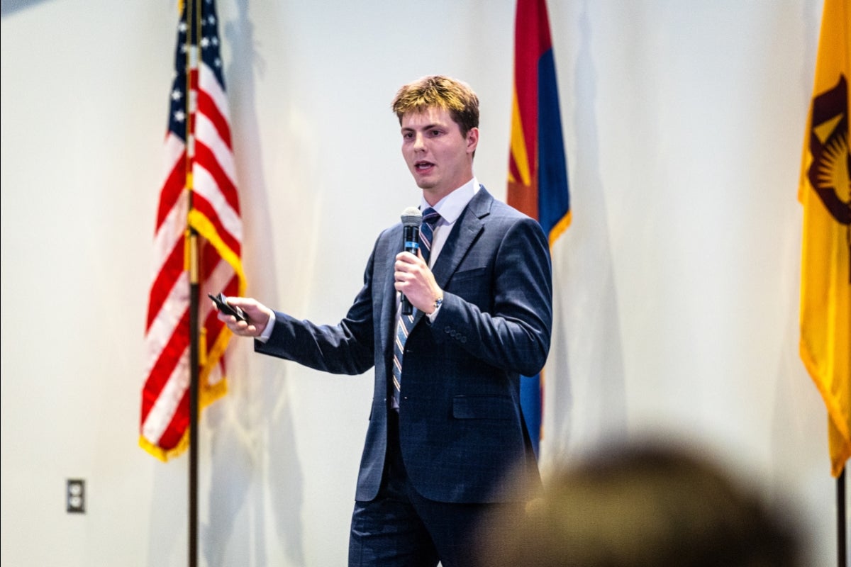 A young man speaks into a microphone