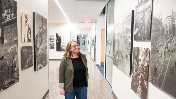 Woman walking in hallway with several large canvas photos on the wall