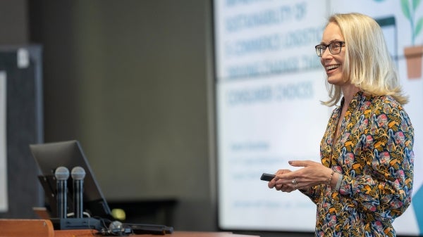 Karen Donohue standing in front of a presentation screen smiling