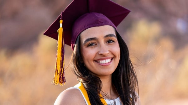 Taylor Jojola smiling with graduation cap on.